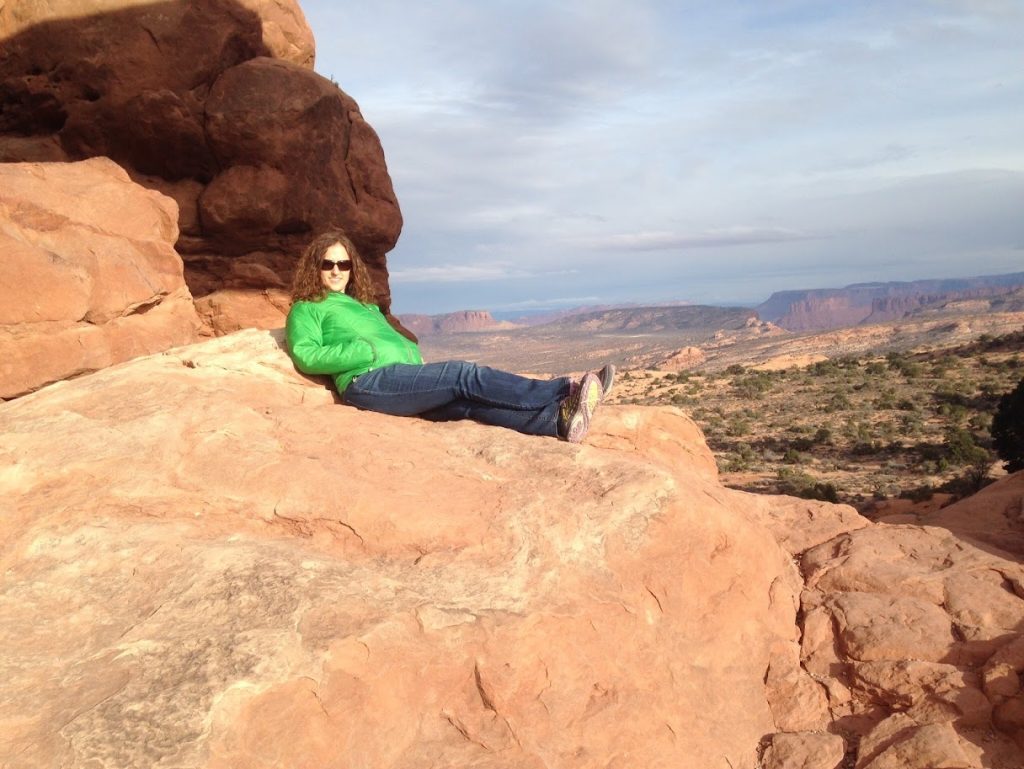 Lucy in the bottom of a large sandstone arch in the winter sun 